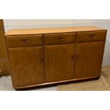 An Ercol sideboard with three drawers and three cupboards under