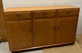 An Ercol sideboard with three drawers and three cupboards under