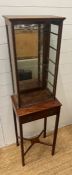 A French display unit with brass shelf brackets and glass shelves mounted on a mahogany side