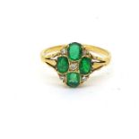 An oval shaped emerald and diamond ring comprising four oval emeralds set with 8 cut diamonds.