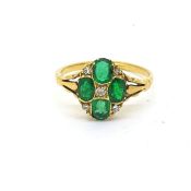 An oval shaped emerald and diamond ring comprising four oval emeralds set with 8 cut diamonds.