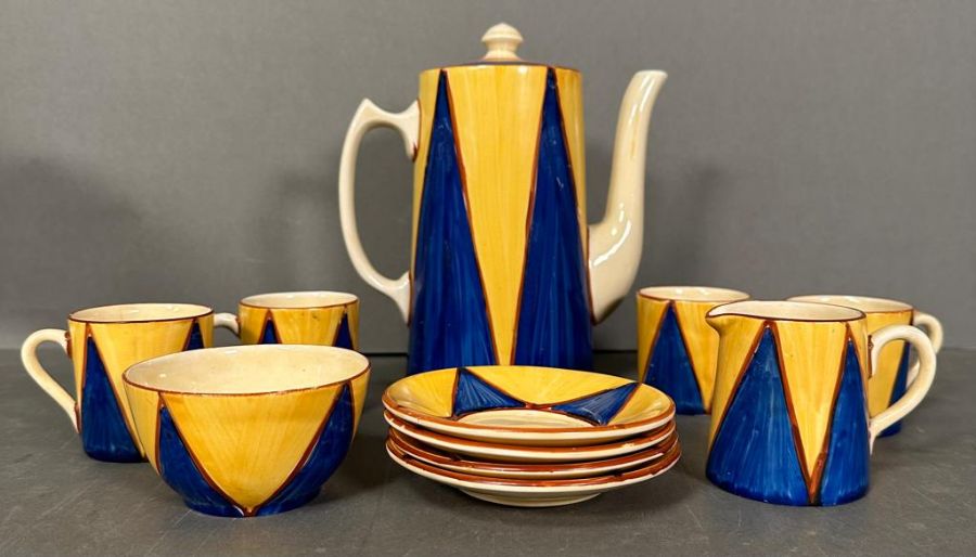A Clarice Cliff Bizarre Coffee service comprising four coffee cans, sugar bowl, milk jug and