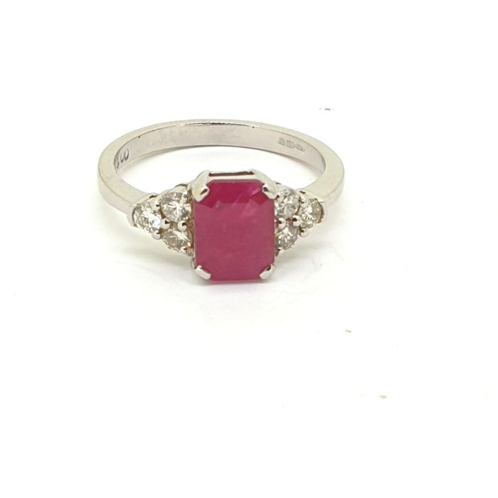 White gold ruby and diamond ring. The central ruby is flanked by three brilliant cut diamonds to