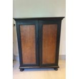 A painted cupboard with panelled doors opening to hanging rail and pigeon holes (H150cm W120cm
