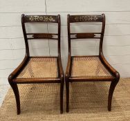 A pair of cane seated regency style chairs with brass inlay.