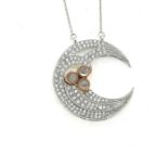 A diamond and moonstone set moon pendant on a fixed chain, marked 9K