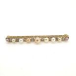 Yellow metal bar brooch 6cm set with alternate pearls graduating in size and diamonds.