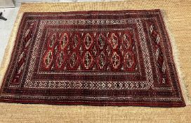 A Persian style red grounds rug 180cm x 117cm