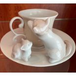 A Lladro cup and saucer with cats playing to side