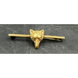 Two gold metal brooches one of three swallows the other of a foxes head.