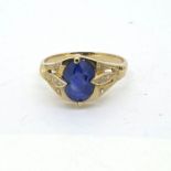 Yellow metal ring with an oval sapphire, decorated to the shoulders with diamonds Size L