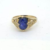 Yellow metal ring with an oval sapphire, decorated to the shoulders with diamonds Size L
