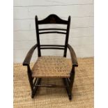 An oak child's rocking chair with reeded seat on inlaid to back