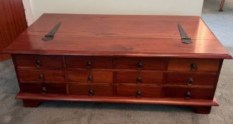 A cherry wood twelve drawer coffee table opening to storage inside (H42cm W118cm D67cm)