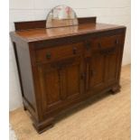 An oak Arts and Crafts style sideboard with original drop handles, the two drawers and cupboards