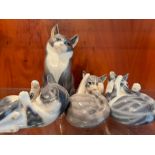 Four Royal Copenhagen china cats, three at play and one seated