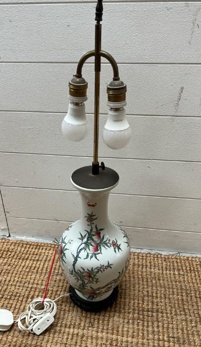A porcelain table lamp decorated with blossom and floral flowers