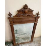 A carved wall mirror with scrolling details to crown or top (H131cm)