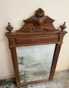 A carved wall mirror with scrolling details to crown or top (H131cm)