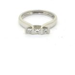 In white gold a three stone ring consisting of 3 princess cut diamonds, marked 750 Size L