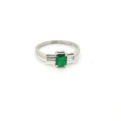 Emerald and diamond three stone ring, central emerald between two baguette diamonds. Emerald