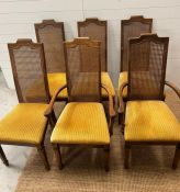 Six cane back dining chairs with upholstered seats and square tapering legs