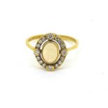Yellow metal ring with an oval opal set inside an oval diamond set halo. Opal estimated to be 0.50