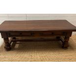An oak coffee table on turned legs and drawers to centre (H42cm W139cm D63cm)