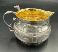 A Victorian silver milk jug with gilded interior, engraved an hallmarked for London 1883 by Holland,