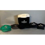 A collection of four Guinness baseball caps and a Guinness top hat