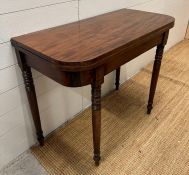 A mahogany card table on turned legs (H75cm W92cm D44cm)