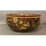 A Lambeth Doulton stoneware Faience bowl with grapes on vine leaves, signed OT and dated 1876 (