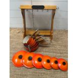 A set of six Le Creuset stoneware saucepans lids and wall hanging rack