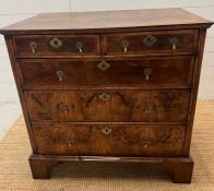 A walnut chest of drawers, two over three with brass drop handles and on bracket feet (Approximate