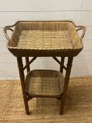 A bamboo style wicker side table with basket style top (H74cm W47cm)