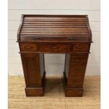 An oak small or child's pedestal roll top desk, six drawers and single cupboards and chair (H91cm