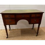 A Regency mahogany inlaid knee hole desk with green leather top consisting of five drawers on turned