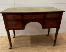A Regency mahogany inlaid knee hole desk with green leather top consisting of five drawers on turned