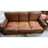 A three seater leather sofa with stud detail to base