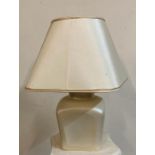 A cream rectangular ceramic based table lamp