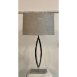 A silver chrome oval table lamp with shade