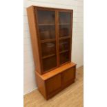 A glazed teak bookcase with cupboard under by Turnbridge of London (H176cm W90cm D43cm)