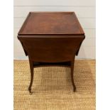 A mahogany side table with hinged sides on down swept legs and castors (H69cm W52cm D48cm)