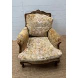 A Louis style upholstered bergère form chair with foliate carved frame