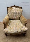 A Louis style upholstered bergère form chair with foliate carved frame