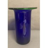 A large cobalt blue glass vase with green rim