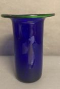 A large cobalt blue glass vase with green rim