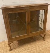 A two shelf display cabinet with leaded glazed doors and sides on cabriole legs