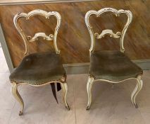 A pair of cream painted chairs