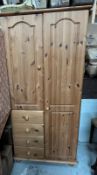 A single pine wardrobe with four drawers and cupboard.